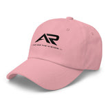 Gorra rosa tipo dad hat con logo AR negro y texto We Are The Vision en la parte frontal.
