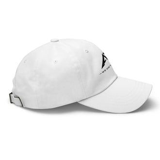 Gorra clásica tipo dad hat blanca de algodón, vista lateral derecha, con ajuste trasero y detalle de logo negro en el frente.