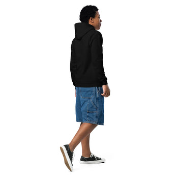 Joven con sudadera negra con capucha vista desde atrás, shorts de mezclilla y tenis negros